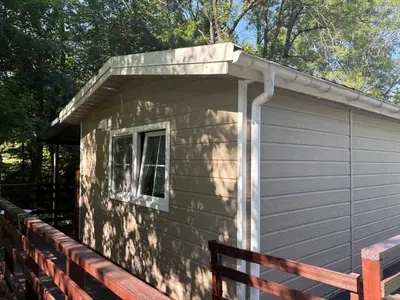 a small building with a porch on a deck at Korzkiewka in Korzkiew