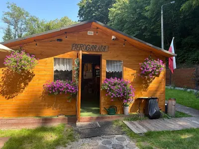 a wooden building with flowers in front of it at Korzkiewka in Korzkiew
