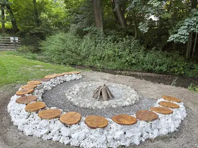a fire pit made out of logs and rocks at Korzkiewka in Korzkiew