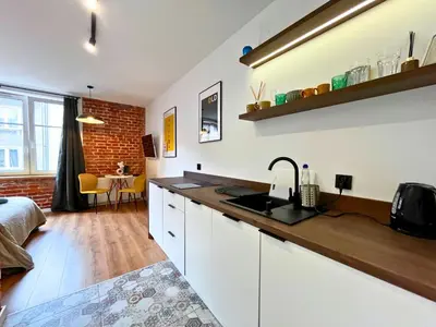 a kitchen with a sink and a counter top at Jacuzzi Kraków Loft - Design Apartments in Kraków
