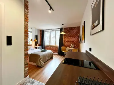a hotel room with a bed and a television in a room at Jacuzzi Kraków Loft - Design Apartments in Kraków