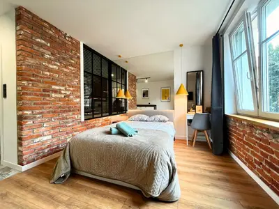 a bedroom with a brick wall and a bed at Jacuzzi Kraków Loft - Design Apartments in Kraków