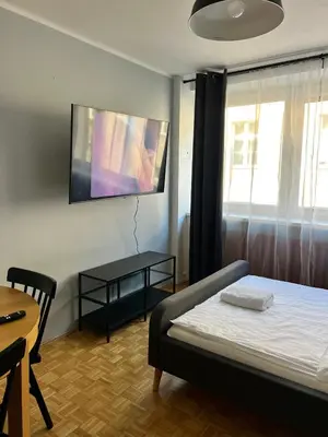 a bedroom with a bed and a table and a window at Main Square Apartment- Tomasza Street in Kraków