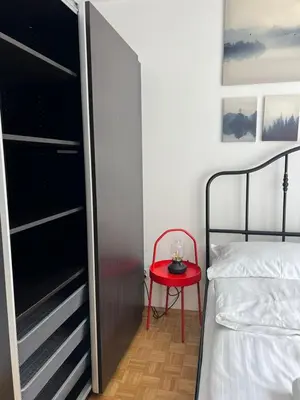 a small bedroom with a red table next to a bed at Main Square Apartment- Tomasza Street in Kraków