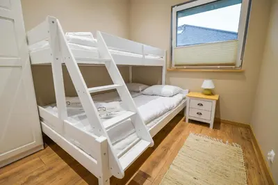 a white bunk bed with a ladder in a room at Sun & Garden House in Oświęcim