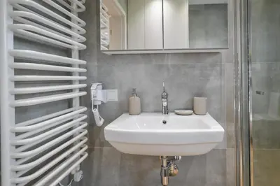 a bathroom with a white sink and a mirror at Sun & Garden House in Oświęcim