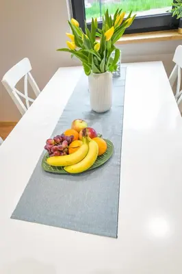 a plate of fruit on a table with a vase of flowers at Sun & Garden House in Oświęcim