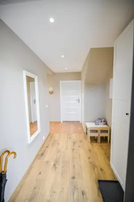 an empty room with a wooden floor and a white door at Sun & Garden House in Oświęcim