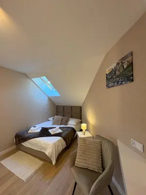 a bedroom with a bed and a chair in it at Babia Perła Zawoja in Zawoja