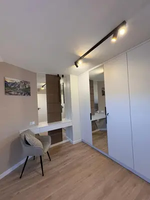 a living room with a chair and a mirror at Babia Perła Zawoja in Zawoja