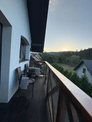 a balcony with chairs and a view of the countryside at Babia Perła Zawoja in Zawoja