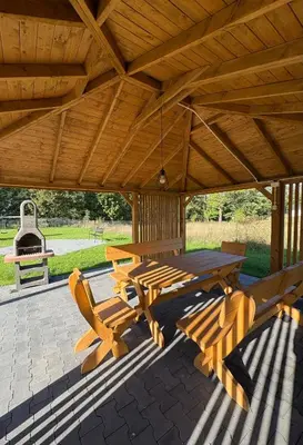 a wooden picnic table and chairs on a patio at Babia Perła Zawoja in Zawoja