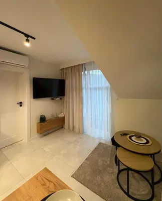 a living room with a table and a flat screen tv at Babia Perła Zawoja in Zawoja