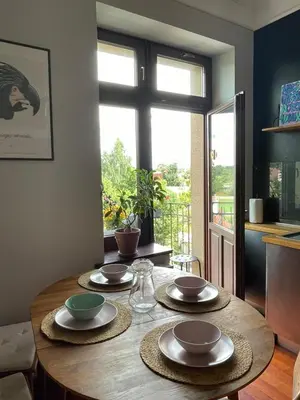 a dining room table with plates and bowls on it at Dodo Acomodo 9 in Kraków