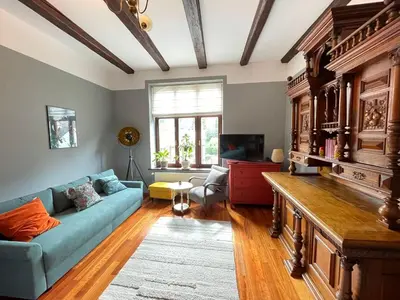 a living room with a blue couch and a tv at Dodo Acomodo 9 in Kraków