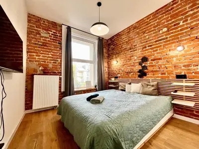 a bedroom with a brick wall and a bed at Urban Loft with Terrace - Design Apartaments in Kraków
