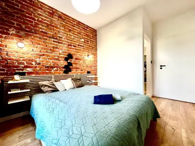 a bedroom with a brick wall and a bed at Urban Loft with Terrace - Design Apartaments in Kraków