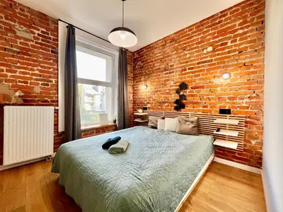 a living room with a couch and a brick wall at Urban Loft with Terrace - Design Apartaments in Kraków