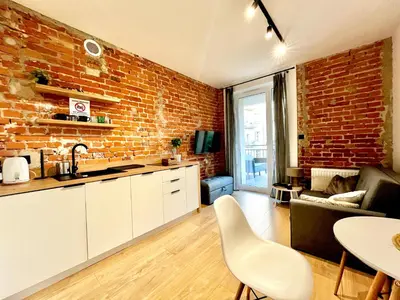 a balcony with couches and a table and a large window at Urban Loft with Terrace - Design Apartaments in Kraków
