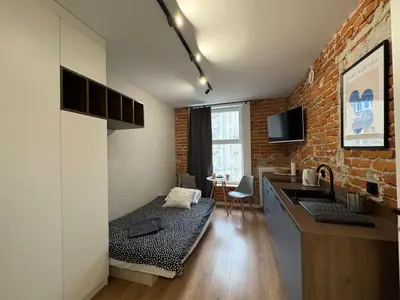 a bedroom with a bed and a table in a room at Comfort Cube - Design Apartaments in Kraków