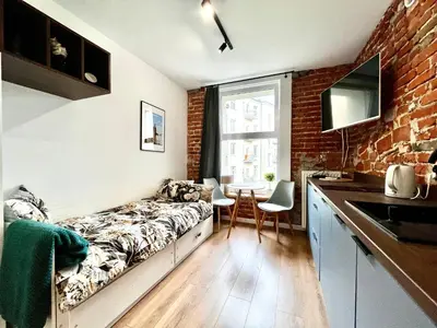 a living room with a couch and a brick wall at Cozy Loft - Design Apartaments in Kraków