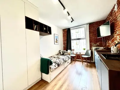 a small bedroom with a bed and a kitchen at Cozy Loft - Design Apartaments in Kraków