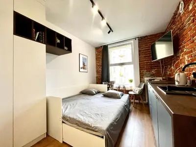 a small room with a bed in a kitchen at Cozy Loft - Design Apartaments in Kraków