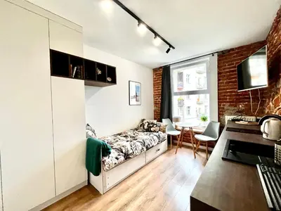 a room with a bed and a table in it at Cozy Loft - Design Apartaments in Kraków