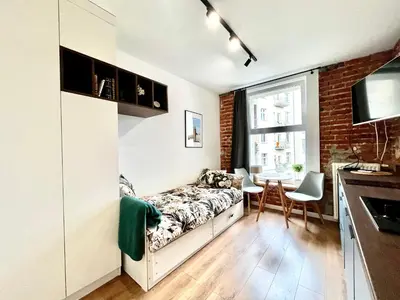 a bedroom with a bed and a table in a room at Cozy Loft - Design Apartaments in Kraków