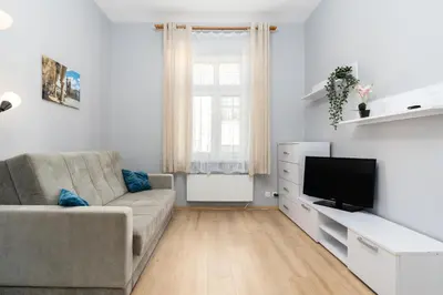 a living room with a couch and a flat screen tv at Cracow Old Town Apartment by BookingHost in Kraków