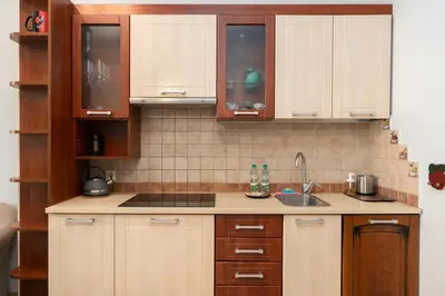 a kitchen with wooden cabinets and a sink at Cracow Old Town Apartment by BookingHost in Kraków