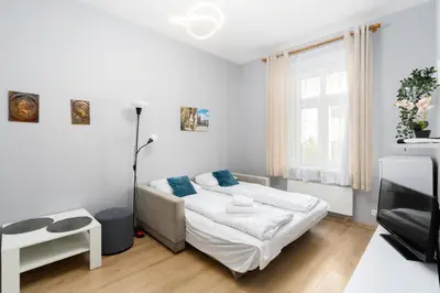 a white bedroom with a bed and a window at Cracow Old Town Apartment by BookingHost in Kraków