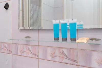 a bathroom with blue and white cups on a shelf at Cracow Old Town Apartment by BookingHost in Kraków