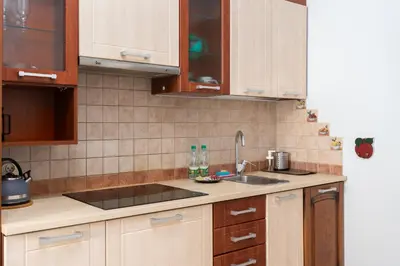 a kitchen with wooden cabinets and a sink at Cracow Old Town Apartment by BookingHost in Kraków