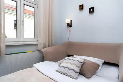 a bed with a pillow and a window in a room at Cracow Old Town Apartment by BookingHost in Kraków