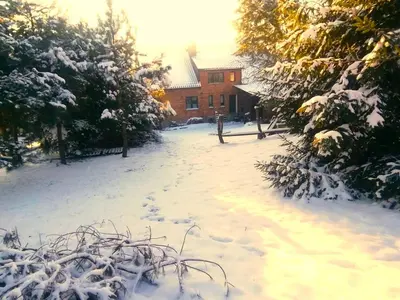 a snow covered yard with a house in the background at A BEAUTIFUL HOUSE near AIRPORT KRAKOW-BALICE