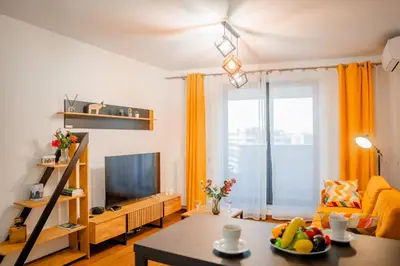 a living room with a television and a table at Krakow Studio Air Con 10th Floor Balcony in Kraków