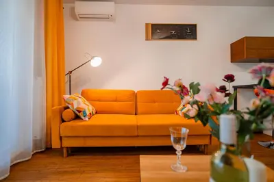 an orange couch in a living room with a table at Krakow Studio Air Con 10th Floor Balcony in Kraków