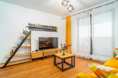 a living room with a television and a table at Krakow Studio Air Con 10th Floor Balcony in Kraków