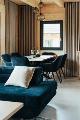 a living room with a couch and a table at Domki Osada Klenina SAUNA & BALIA in Kamienica