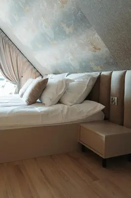 a bed with pillows on it with a ceiling at Domki Osada Klenina SAUNA & BALIA in Kamienica