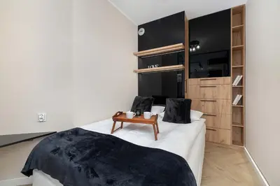 a bedroom with a white bed with a table on it at Grzegórzecka 69E Kraków Bright Apartment Near Centre in Kraków