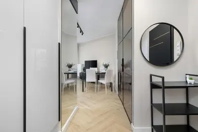 a dining room with a mirror and a table at Grzegórzecka 69E Kraków Bright Apartment Near Centre in Kraków