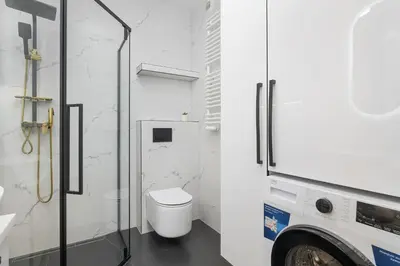 a white bathroom with a toilet and a shower at Grzegórzecka 69E Kraków Bright Apartment Near Centre in Kraków