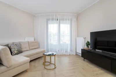 a living room with a couch and a flat screen tv at Grzegórzecka 69E Kraków Bright Apartment Near Centre in Kraków