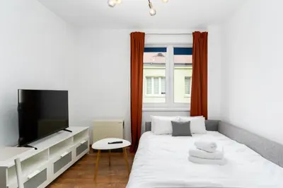 a white bedroom with a large white bed with white pillows at Sewera Cozy Nest Apartment by BookingHost in Kraków