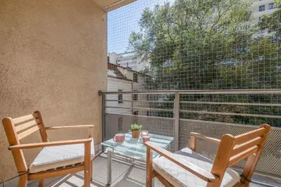 a balcony with two chairs and a glass table at Kazimierza Wielkiego 2-Bedroom Apartment with Parking by Noclegi Renters in Kraków