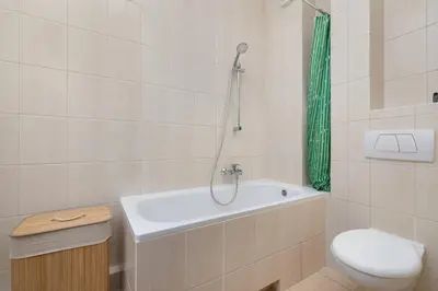 a bathroom with a tub and a toilet and a shower at Kazimierza Wielkiego 2-Bedroom Apartment with Parking by Noclegi Renters in Kraków