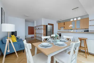 a dining room and kitchen with a table and chairs at Kazimierza Wielkiego 2-Bedroom Apartment with Parking by Noclegi Renters in Kraków