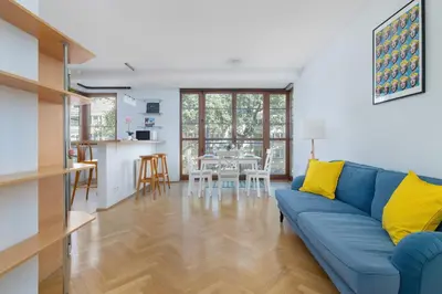 a living room with a blue couch and a kitchen at Kazimierza Wielkiego 2-Bedroom Apartment with Parking by Noclegi Renters in Kraków